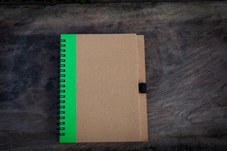 brown cover notebook on dark wood textureの写真素材