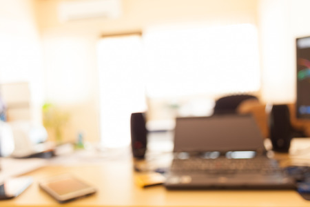 blur office table with laptop and smartphoneの写真素材
