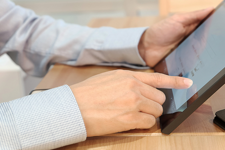 young asian businessman hand on computer tablet, business communication conceptの写真素材