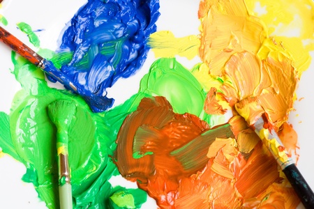 Three fitch brushes and different water paints on the white paper