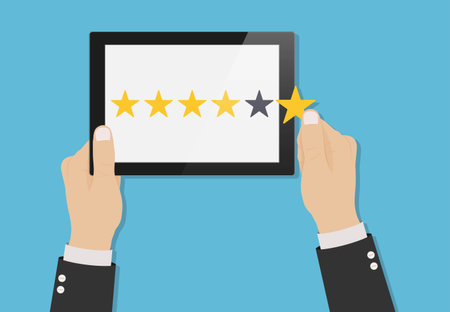 Hand holding tablet with yellow rank stars on screen. Concept of feedback. Template design of voting, rating, customer reviews and evaluation. Vector illustrationのイラスト素材