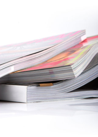 Stack of glossy magazines on a white background.