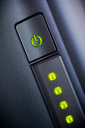Green glowing power button. Closeup shot.