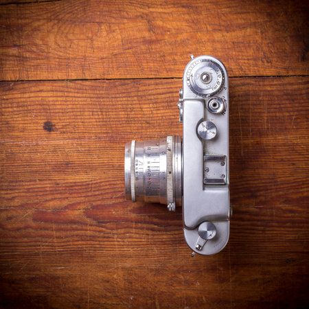 Vintage photo camera on a wooden background, top view