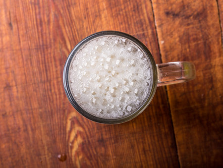 glass of fresh lager beer on wooden table.の写真素材