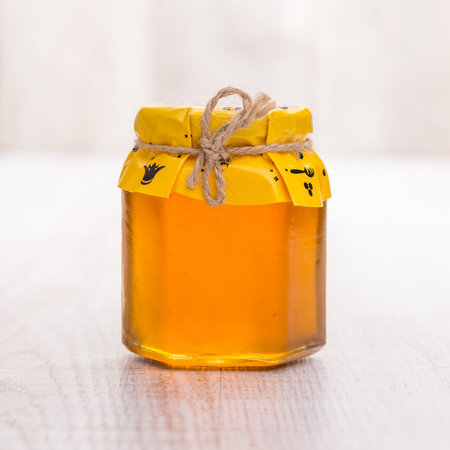 Jar of honey on wooden table.の写真素材