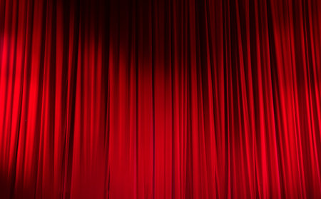 Red closed curtain with light spots in a theater.の写真素材