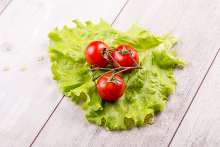 Tomato and green salad on wood background.の写真素材