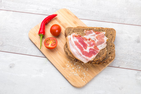 Healthy breakfast with tomato, toasts, meat on wooden tableの写真素材