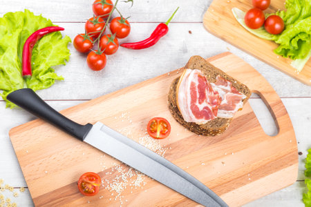 Healthy breakfast with tomato, toasts, meat and salad on wooden table
