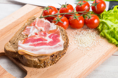 Healthy breakfast with tomato, toasts, meat and salad on wooden tableの写真素材
