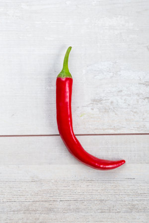 Red hot chili peppers on old wooden table.の写真素材
