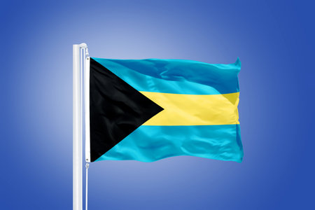 Flag of Bahamas flying against a blue sky.の写真素材