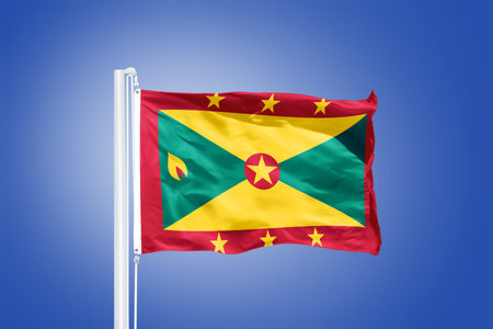 Flag of Grenada flying against a blue sky.の写真素材