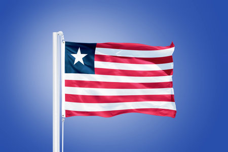 Flag of Liberia flying against a blue sky.の写真素材