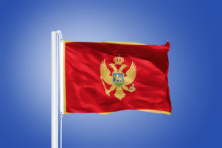 Flag of Montenegro flying against a blue sky.の写真素材