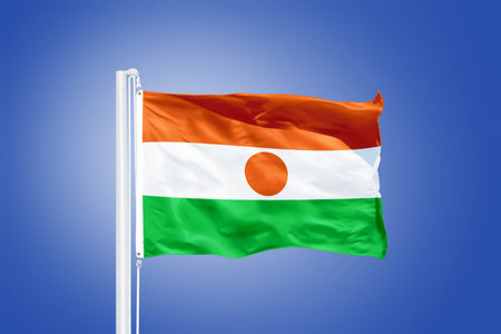 Flag of Niger flying against a blue sky.の写真素材