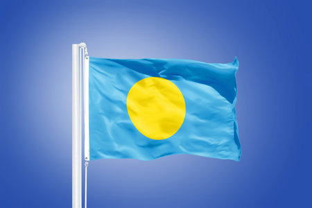 Flag of Palau flying against a blue sky.の写真素材