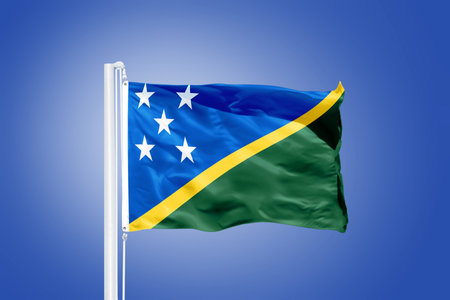 Flag of Solomon Islands flying against a blue sky.の写真素材