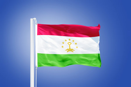 Flag of Tajikistan flying against a blue sky.の写真素材