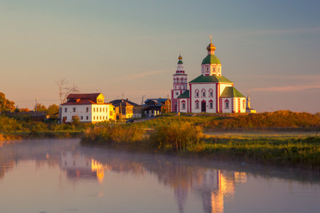 Orthodox church on the green lawn near the river, the city of Suzdal Russiaの写真素材