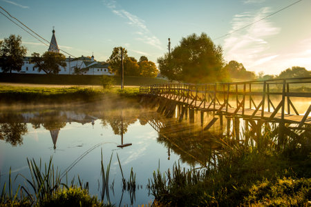 wooden bridge through river in morning sunlight.の写真素材