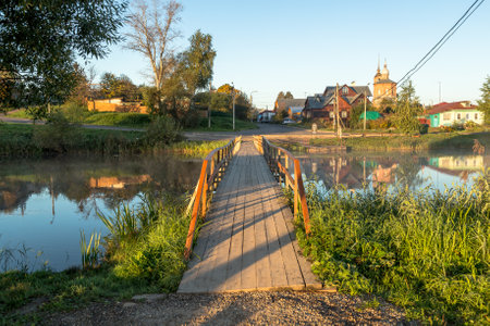 wooden bridge through river in morning sunlight.の写真素材