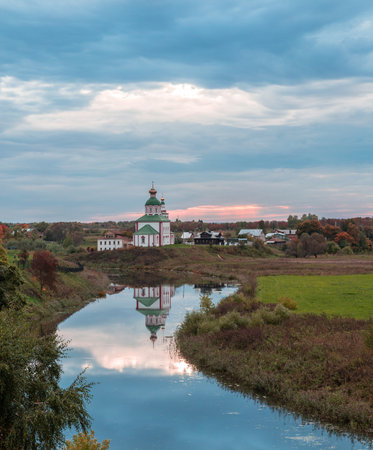 Orthodox church on the green lawn near the river, the city of Suzdal Russiaの写真素材