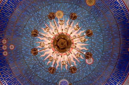 A chandelier from bottom view with colorful ceiling made from tiles as backgroundの写真素材