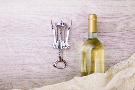 Wine bottle with corkscrew on wooden background.の写真素材
