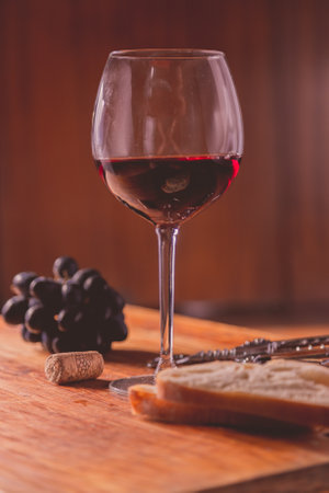 Pouring red wine glass against wooden backgroundの写真素材