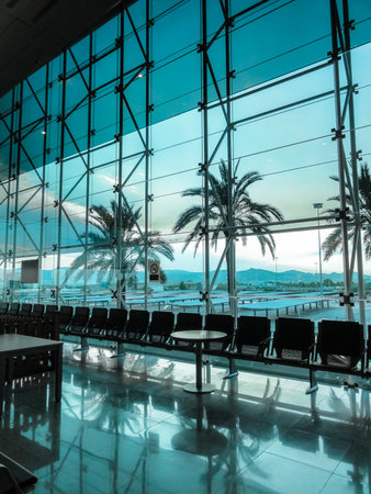 row of seats at airport against palms.の写真素材