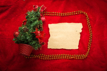 Design a Christmas greeting card with white paper on a red background.の写真素材
