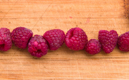 Ripe sweet raspberries on wood table close-up.の写真素材