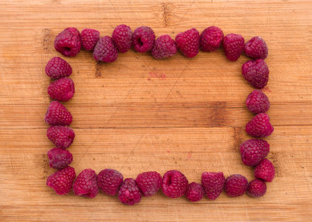 Ripe sweet raspberries on wood table close-up.の写真素材