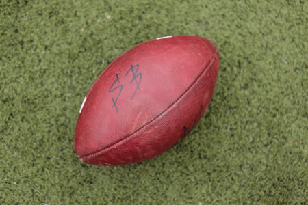 American football rugby ball on green grass close up.