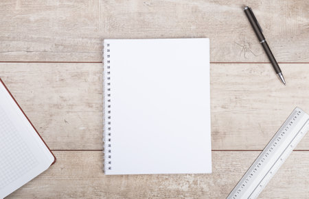 Notepad and pen on wooden table.