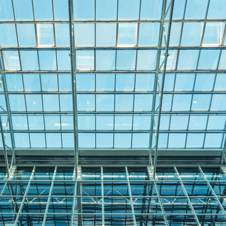 Glass roof of modern office building with outside blue sky