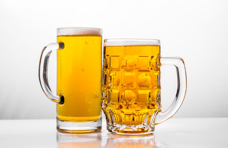 Two Mugs of fresh beer with cap foam