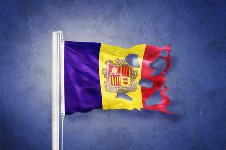 Torn flag of Andorra flying against grunge backgroundの写真素材