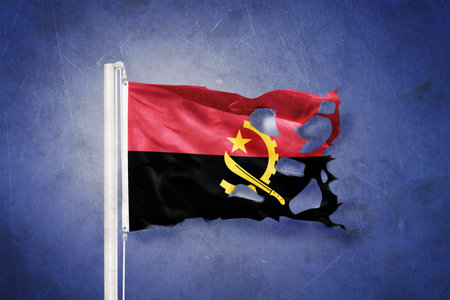 Torn flag of Angola flying against grunge backgroundの写真素材