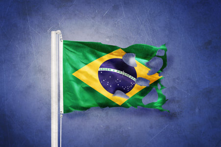 Torn flag of Brazil flying against grunge backgroundの写真素材
