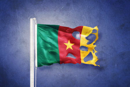Torn flag of Cameroon flying against grunge backgroundの写真素材