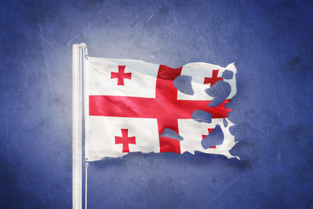 Torn flag of Georgia flying against grunge backgroundの写真素材