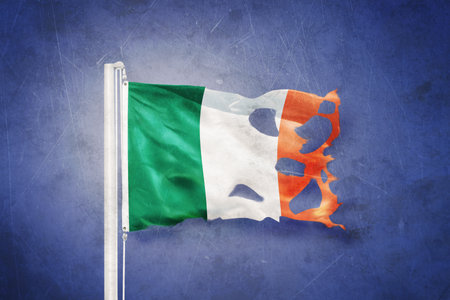 Torn flag of Ireland flying against grunge backgroundの写真素材