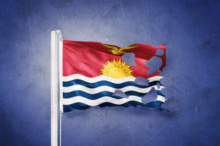 Torn flag of Kiribati flying against grunge backgroundの写真素材