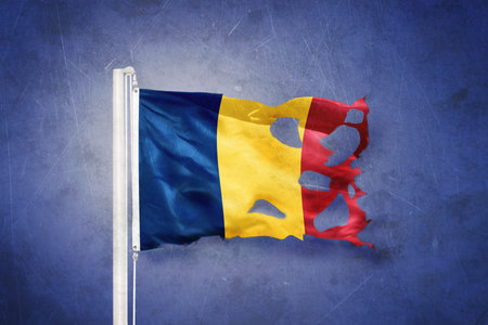 Torn flag of Romania flying against grunge backgroundの写真素材