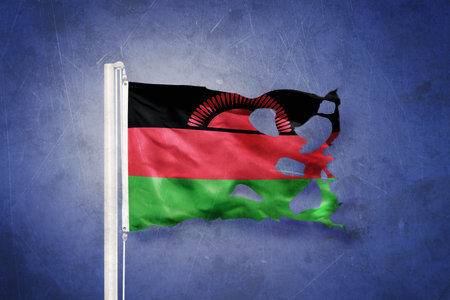 Torn flag of Malawi flying against grunge backgroundの写真素材