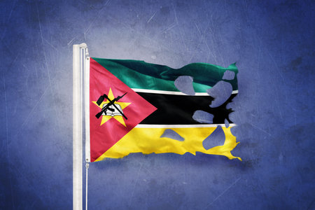Torn flag of Mozambique flying against grunge backgroundの写真素材