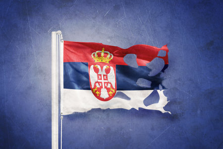 Torn flag of Serbia flying against grunge backgroundの写真素材